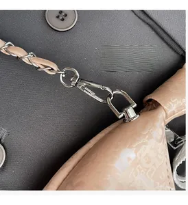 Detail of silver chain strap with woven leather and embossed texture on women's bag