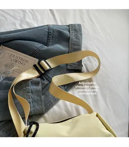 Détail de la bandoulière large réglable avec boucle noire sur sac en toile jaune clair