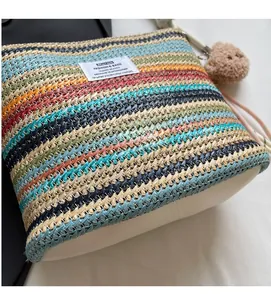 Close-up of colorful striped woven bucket bag with smooth white base and bear charm