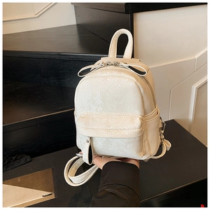Close-up of cream white mini backpack featuring detailed snake skin embossed texture