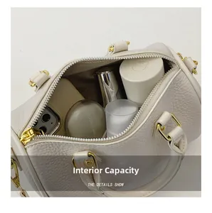 Detail view of white pebbled leather boston bag showing spacious interior capacity