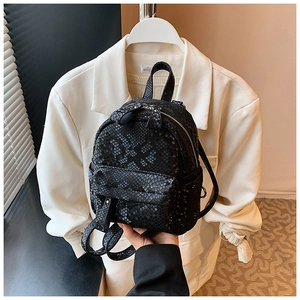 Close-up of black snakeskin texture and zipper detail on a mini lightweight backpack