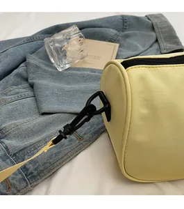 Close-up of durable black shoulder strap hook on a yellow textured pillow bag