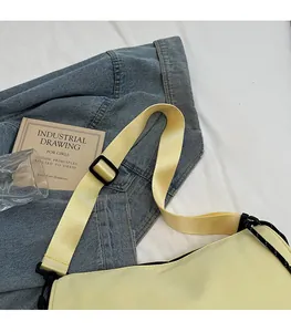 Detail of adjustable strap on a yellow pillow bag with black plastic buckle and hook