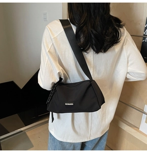 Détail du sac bandoulière noir avec large sangle et logo MOONLERSA imprimé dessus