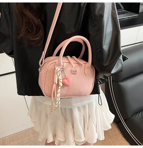 Détail du sac Boston en cuir PU rose avec lettres FAN TOR et breloque en cœur