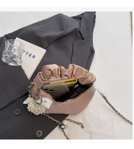 Interior detail of a pleated apricot shoulder bag showing spacious storage and lining