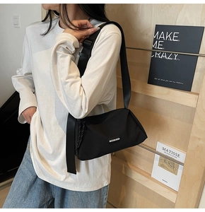 Détail du sac bandoulière en nylon noir minimaliste avec large sangle réglable et cordon