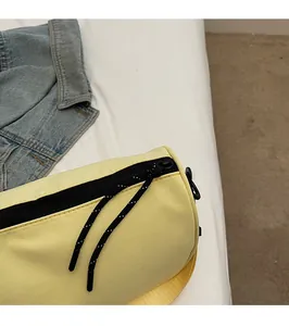 Detail of yellow nylon bag showing smooth black zipper with white-dotted cord pulls