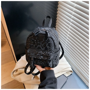 Detailed view of the black snake-pattern faux leather mini backpack with metal zipper