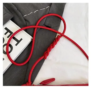 Détail du sac besace rouge avec bandoulière en corde torsadée et fermeture éclair argentée