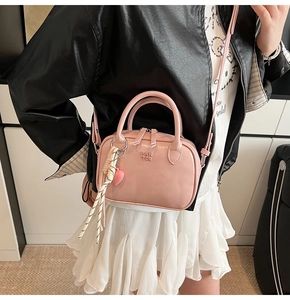 Détail d'un mini sac docteur rose avec pendentif coeur et corde tressée sur le sac à main