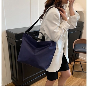Navy blue large capacity tote bag styled with white blazer in a lifestyle setting