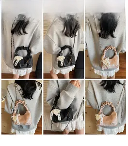 Detailed close-up of pleated handle hobo bag with pearl bow charm and chain strap