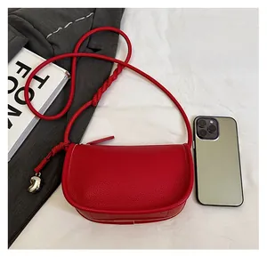 Sacoche rouge à motif litchi montrant la taille par rapport à un smartphone