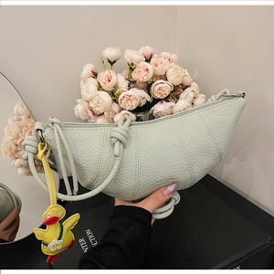 Detail of mint green half-moon bag featuring lychee texture and a cute duck charm