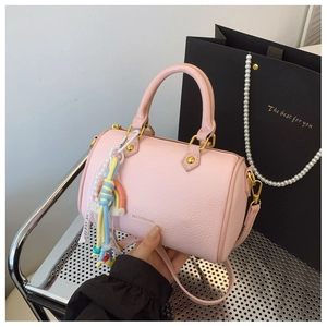 Pink lychee grain Boston bag with gold hardware and pearl rainbow pendant detail