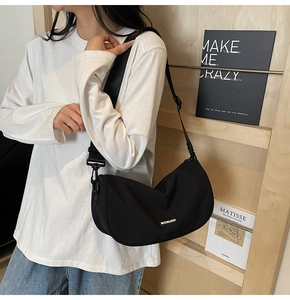 Detail of black nylon crescent bag with Moonleasa logo and adjustable wide strap