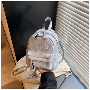 Close-up of stylish mini backpack with silver snake skin texture and metal zippers