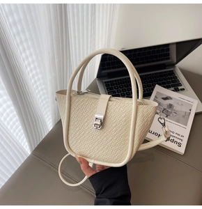 Détail du sac à main crème avec texture crocodile et boucle en métal argenté élégante