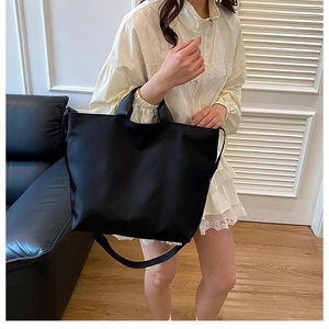 Black large capacity nylon tote bag shown with dual handles and long shoulder strap