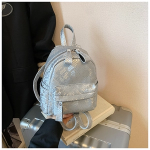Close-up of silver mini backpack with snakeskin texture and functional front zipper