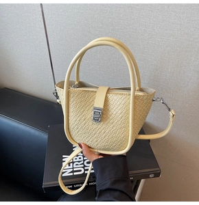 Macro detail of yellow crocodile pattern leather bag with silver B-shaped metal clasp