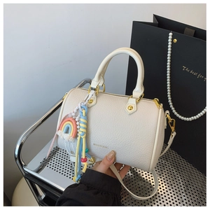 Detail of off-white lychee texture Boston bag with rainbow charm and gold hardware