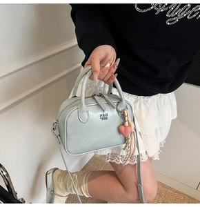 Détail du sac bandoulière en cuir vert menthe avec pendentif cœur et logo PAN TOR