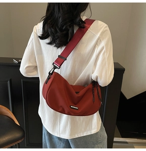 Detail of red crescent nylon crossbody bag with adjustable wide strap and logo patch