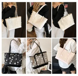 Detail van grote shopper tassen met 3D-bloemborduursel in diverse kleuren en leren riemen