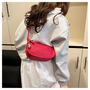 Détail du sac bandoulière rouge en cuir grainé avec pendentif goutte d'eau argenté