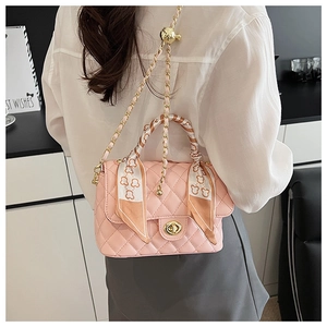 Detailed view of pink quilted box bag with silk scarf handle and gold chain strap