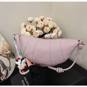 Close-up of pink crescent bag with lychee texture and cute white duck charm accessory