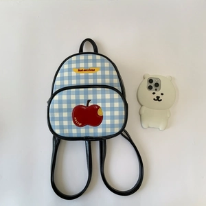 Dettaglio mini zaino a scacchi blu con toppa a mela e spalline sottili nere