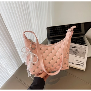 Pink quilted shoulder bag with rhinestones and pearl lace bow charm detail