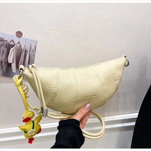 Macro shot of cream crescent bag with lychee grain leather and cartoon duck charm