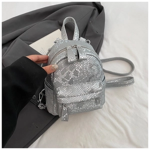 Close-up of a silver mini backpack with snakeskin texture and metallic finish details