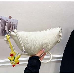 Detail of off-white grain leather crescent bag with knot handle and duck charm