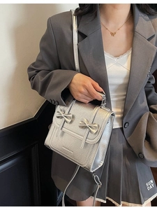 Silver metallic crossbody bag with leather bows and textured finish for summer fashion