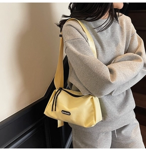 Détail du sac bandoulière en toile jaune avec large sangle et logo MOONLEASA