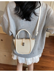 Fashionable woven texture bucket bag in creamy white with dual handles and crossbody strap