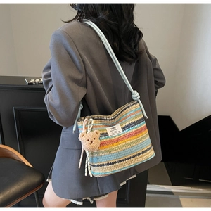Close-up of a colorful striped woven bucket bag featuring a cute brown bear charm