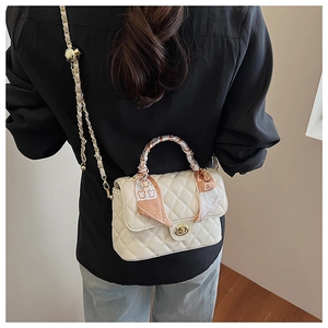Fashionable white quilted box bag with a decorative floral scarf on handle and gold buckle