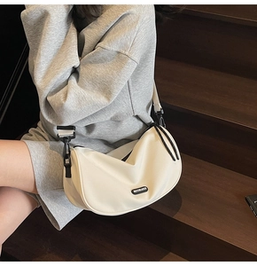 Close-up of minimalist white crescent shoulder bag featuring adjustable buckle and MOONLEASA logo