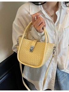 Fashionable bright yellow woven bucket bag with top handles and adjustable shoulder strap