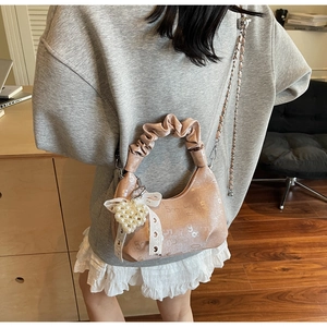Detail of pink pleated handbag featuring numerical texture, lace bow and pearl heart charm