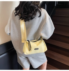 Modèle portant un sac bandoulière en toile jaune avec sangle et détail du logo Moonlersa