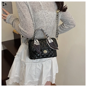 Quilted crossbody box bag with metal lock and silk scarf wrapped on the handle