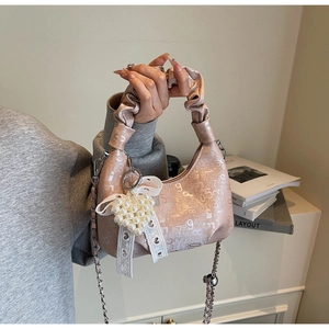 Detail of light pink pleated bag with digital pattern, pearl heart and lace bow accent